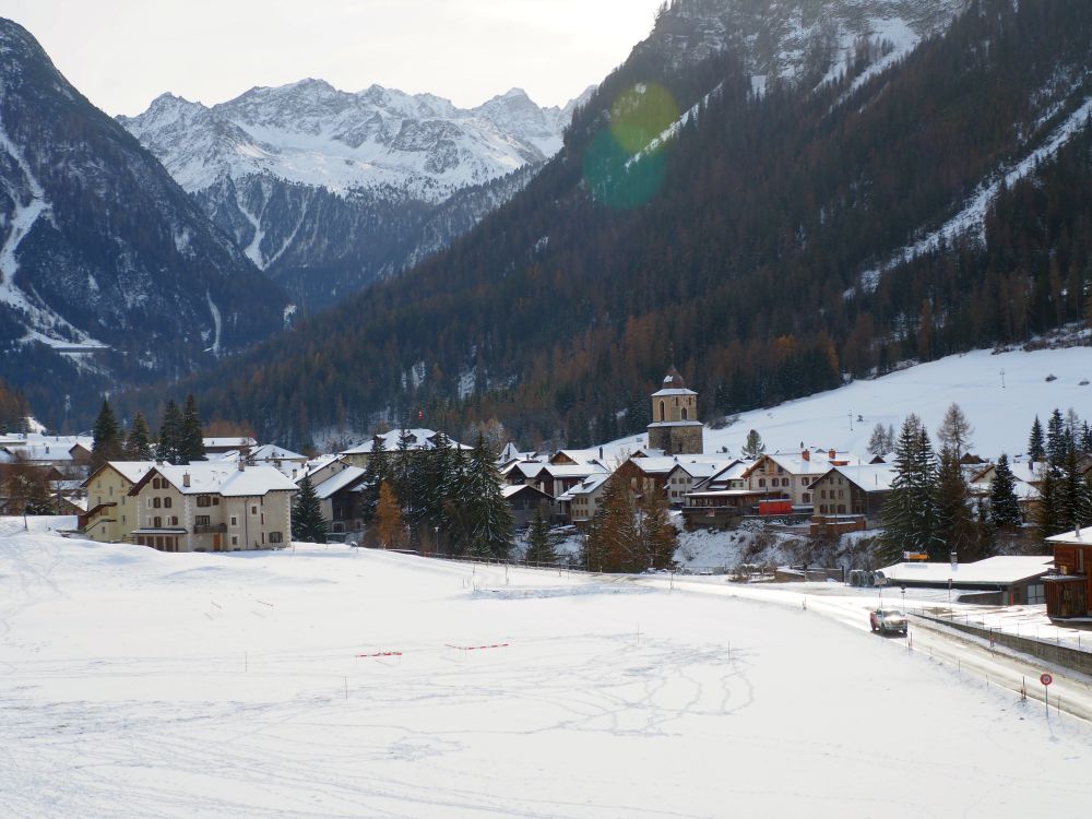 A small village clustered in a valley surrounded by mountains.