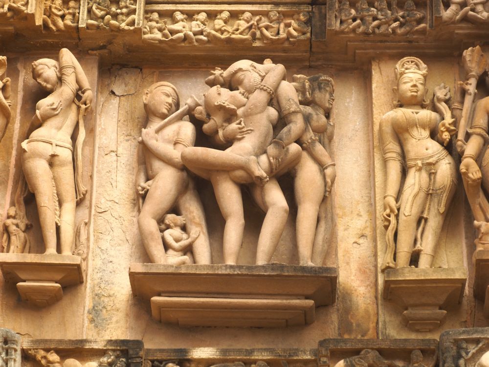 An erotic image of a man and a woman with a man and a woman on either side of them.