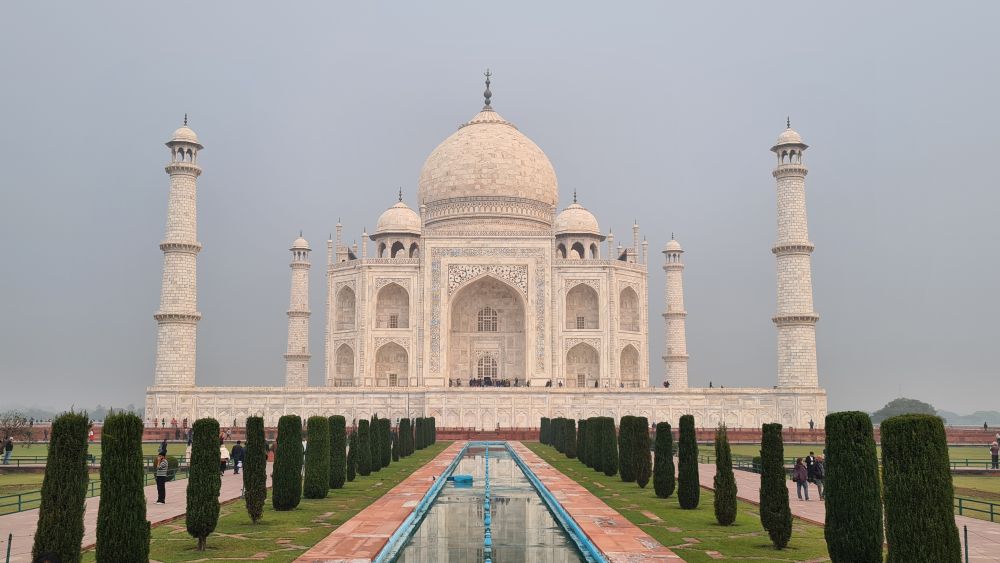 The Taj Mahal - white building with white domes and minarets at the corners.