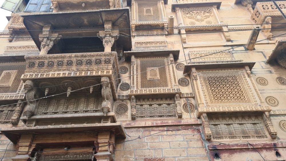 Decorative stonework creating mesh screens on a haveli facade.