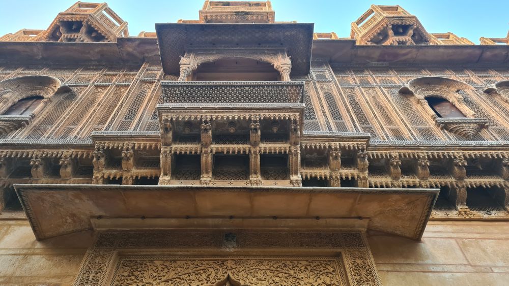 The entrance to a haveli with its very ornate caved stone window frames and screens.