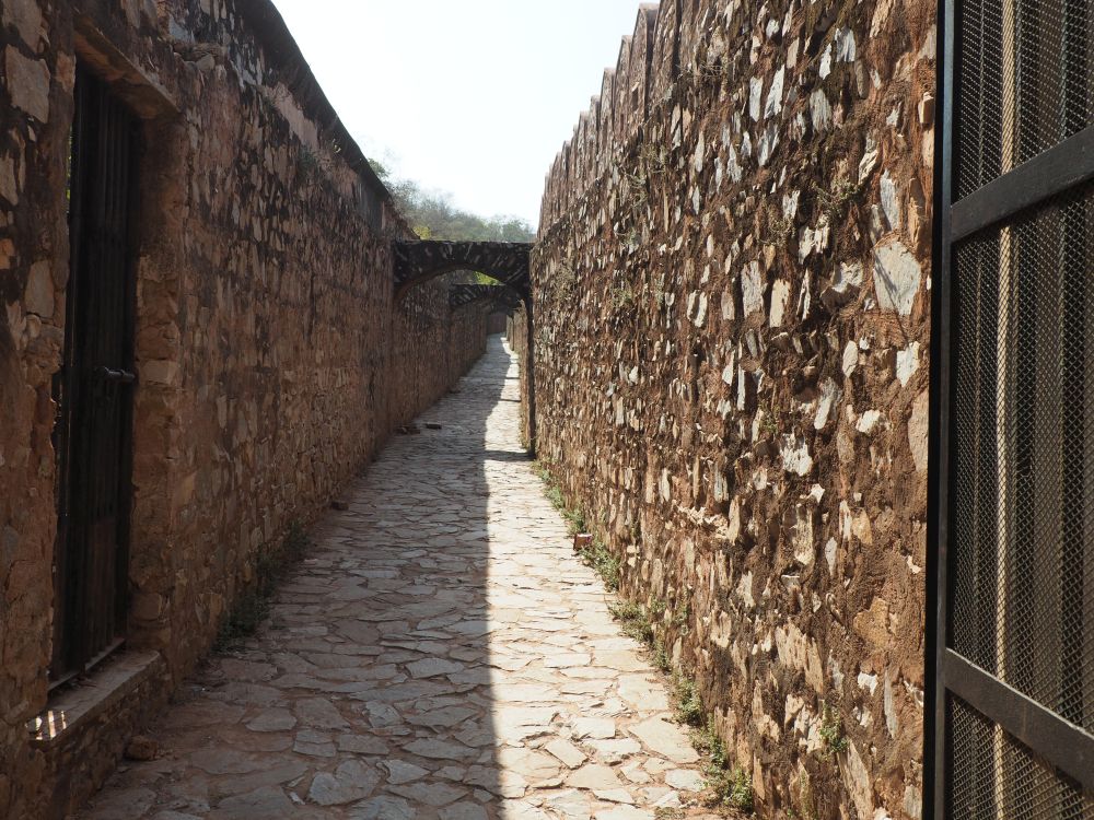 A cobbled path with high stone walls on both sides.