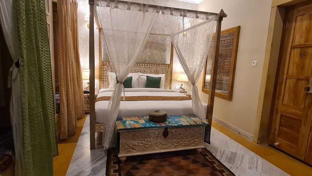 A bedroom with a four-poster bed and pretty details in the furniture. 