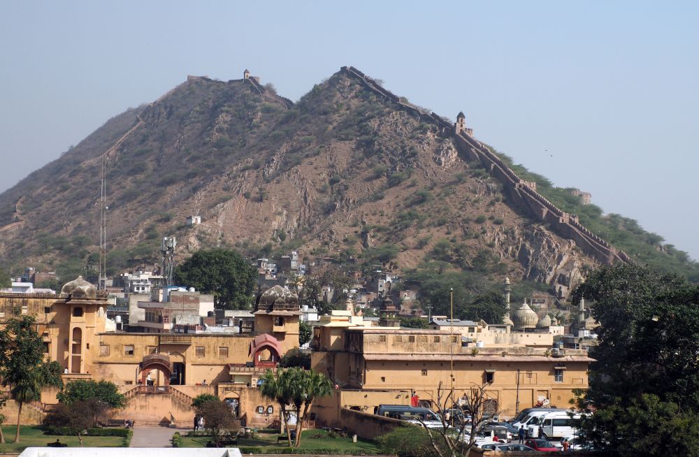 Two mountain peaks in the distance, with a wall snaking its way up and over along their ridges.