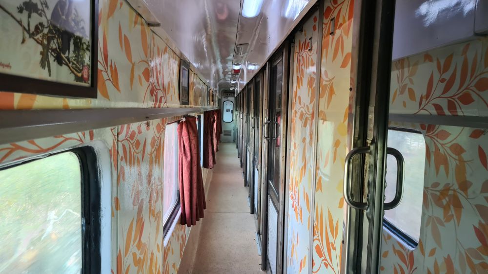 Looking down a train aisle: windows along the left, compartments on the right.