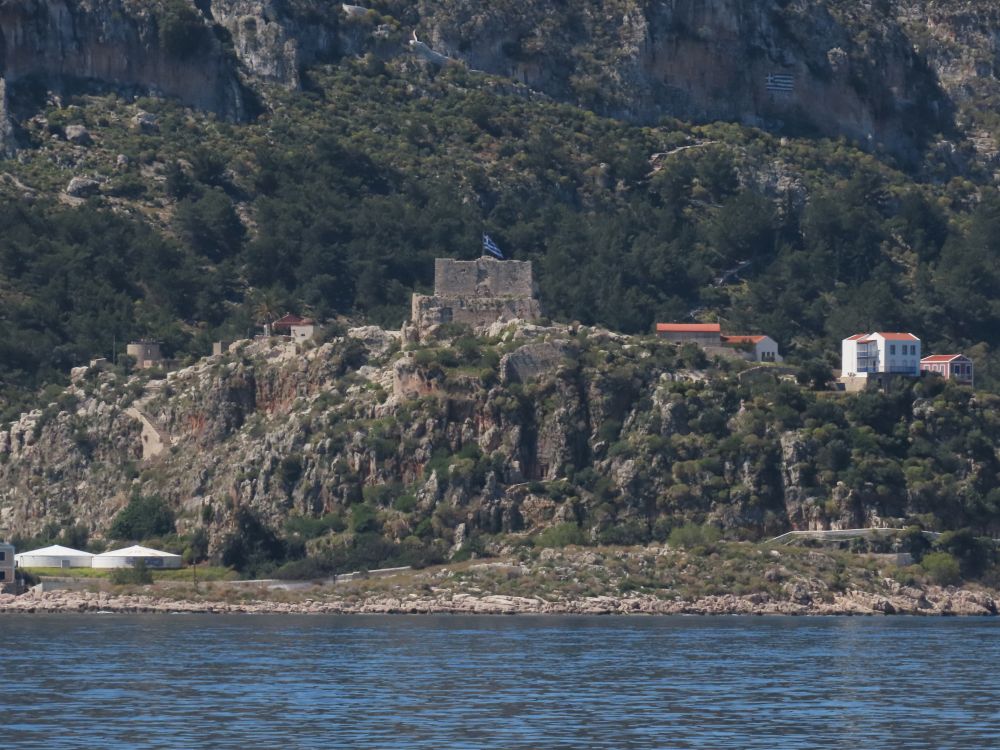 Looking from the sea to the land, a square tower on a hill.