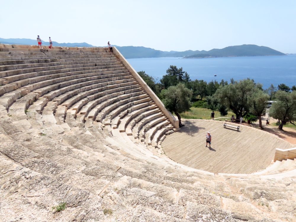 A stone amphitheater - quite large, with many rows of seats in a semicircle rising high above the round stage.