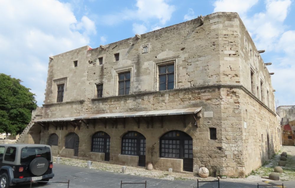 A two-story stone building with arched windows on the ground floor.