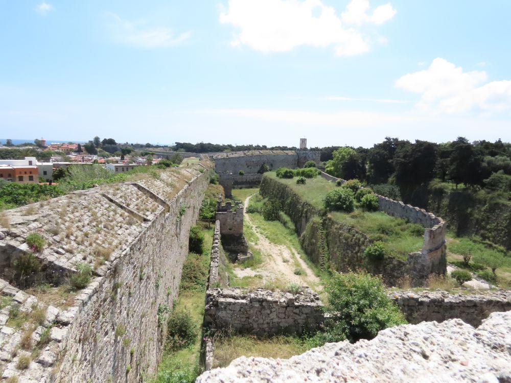A view along a long wall and along the moat beside it.