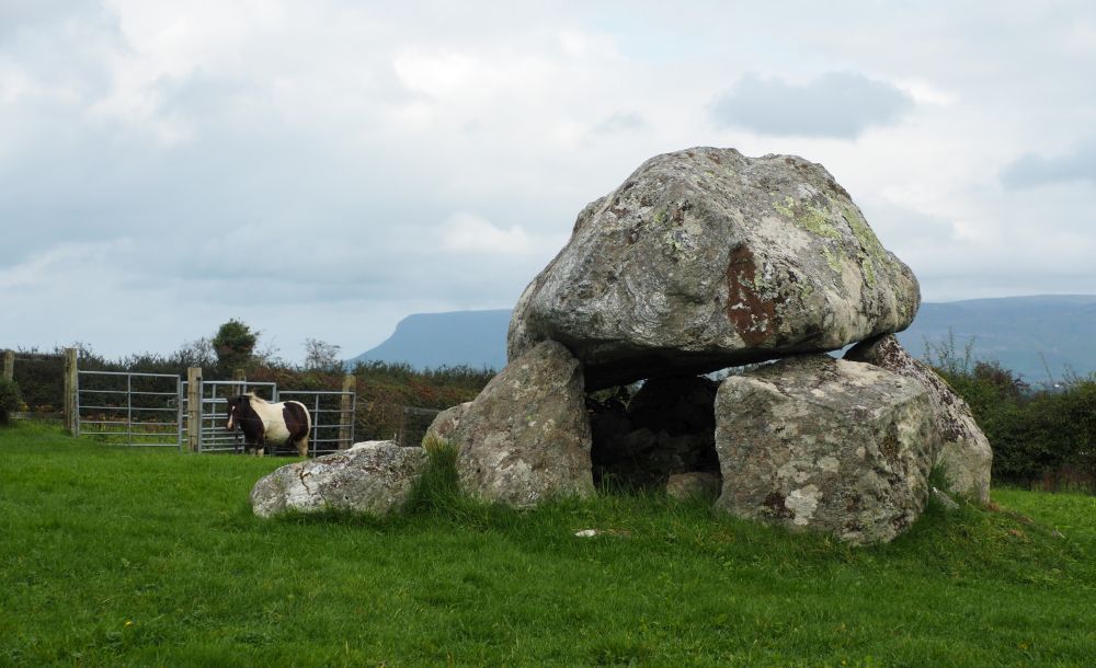 Large rocks stand, supporting an even larger rock on top.