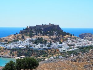 View of the whole acropolis on its high rock, with the village of Lindos clustered around its base.