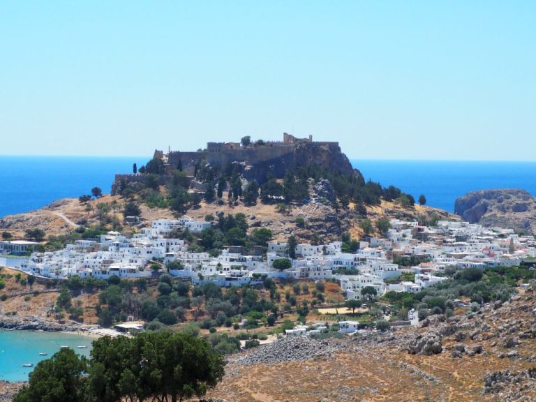 View of the whole acropolis on its high rock, with the village of Lindos clustered around its base.