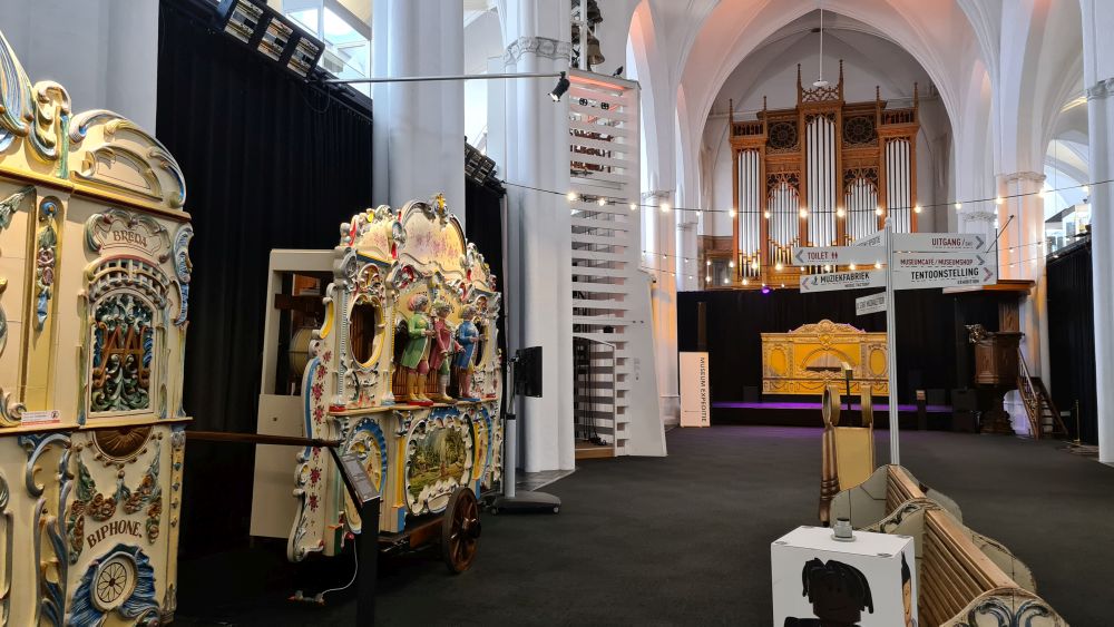 View down the center of the former church: organs on one side, the church organ straight ahead, arches and pillars of the central apse of a church.