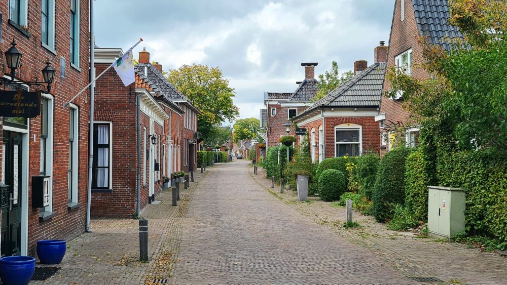 Looking down a street lined with small brick houses.