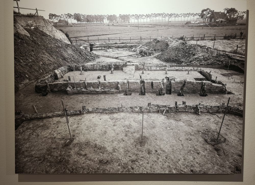 A black and white photo showing the low wall in a rectangular shape with here and there a pole sticking out of its inner floor.