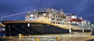 The ship Havila Polaris docked next to a wharf.