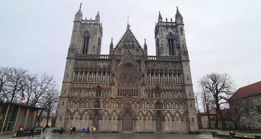 A flat-fronted cathedral with two spires. The front has rows of dozens of statues.