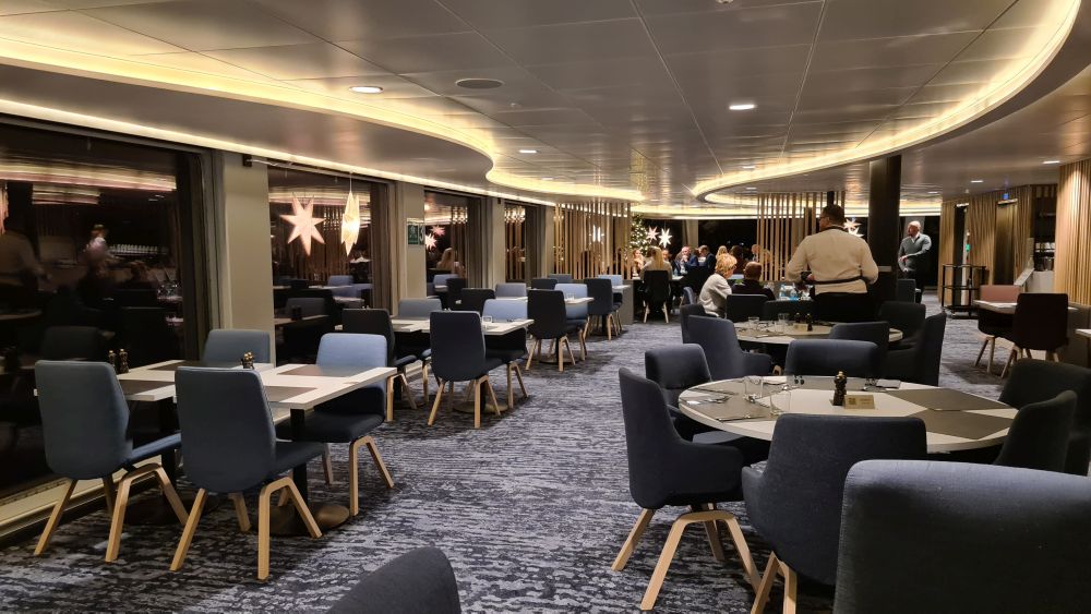 tables scattered around, with grey chairs around them.