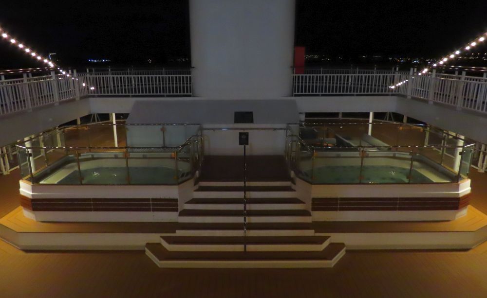 A central half-flight of stairs leads up to a large square jacuzzi on either side of it.