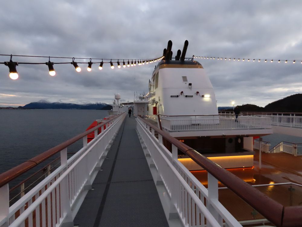 A narrow walkway with railings on either side goes along the side of the ship.