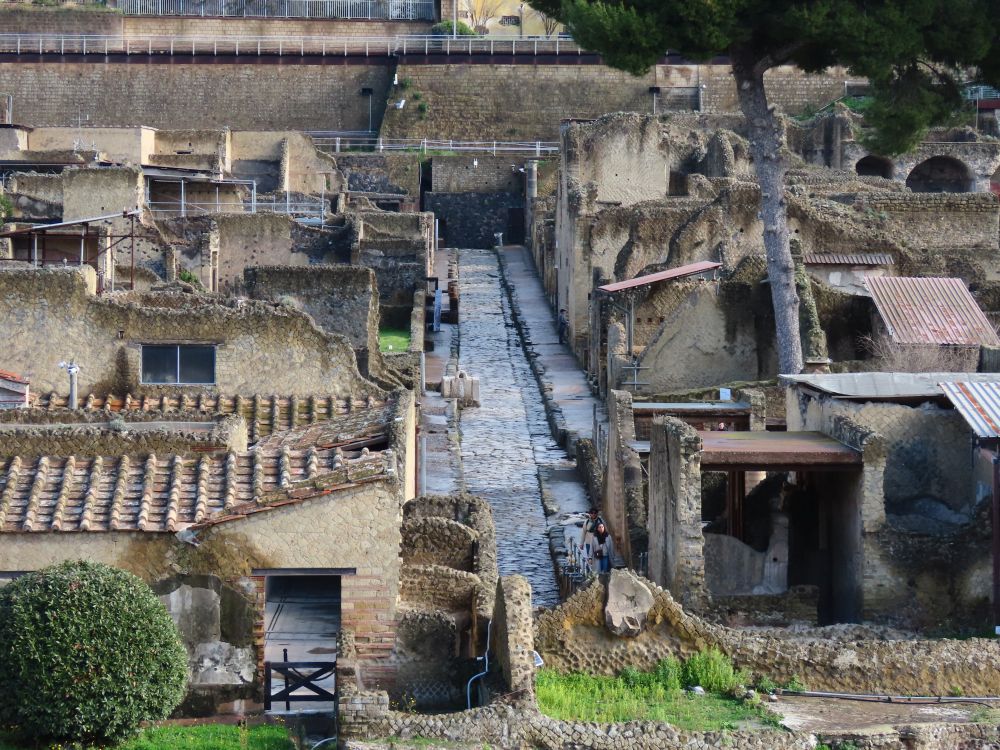 Seen from a distance, looking down along a road - very straight and neat, with stone houses on either side.