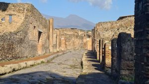 A stone-paved street, raised sidewalks on either side, stone walls along the sidewalks.