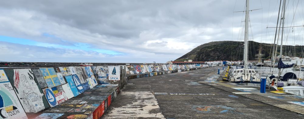 A view along the breakwater, with painted patches on the wall to the left.