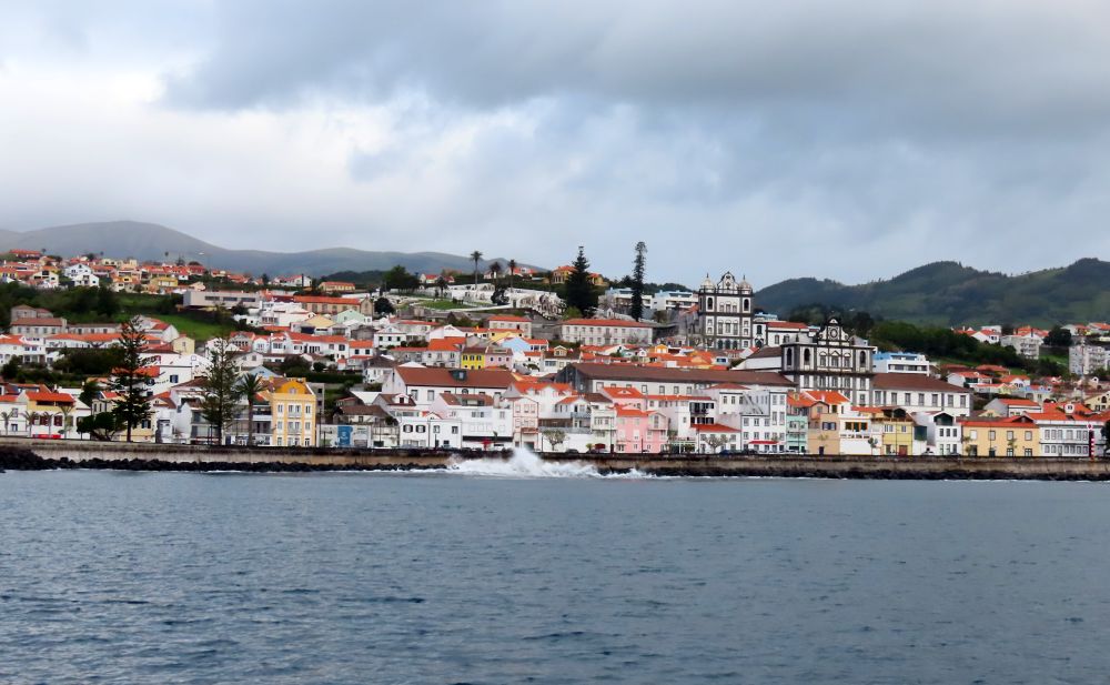 The buildings cluster along a sea wall, mostly white, with a few churches taller than the others.