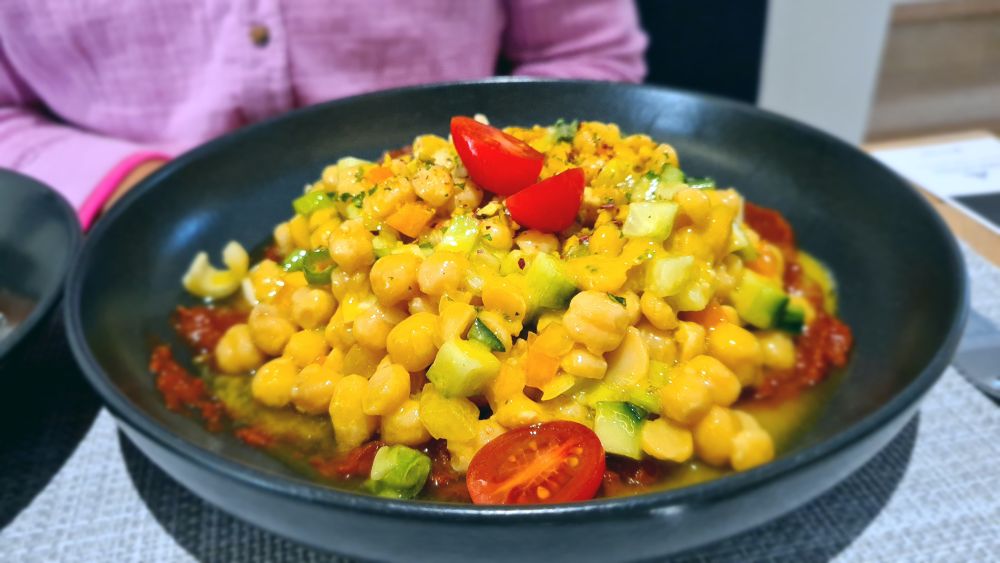 A black shallow bowl filled with chickpea salad.