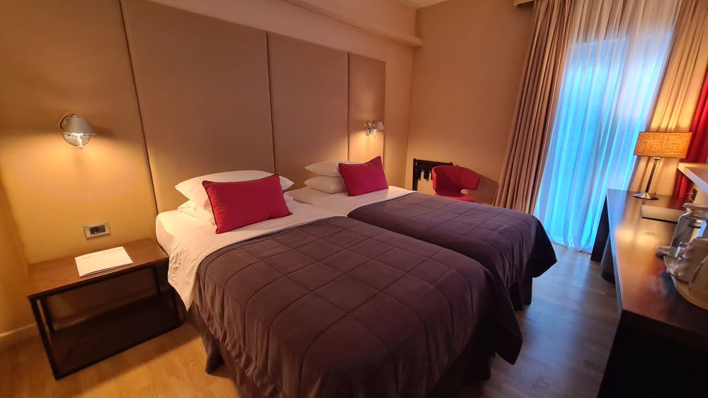 The room has beige walls and 2 twin beds.