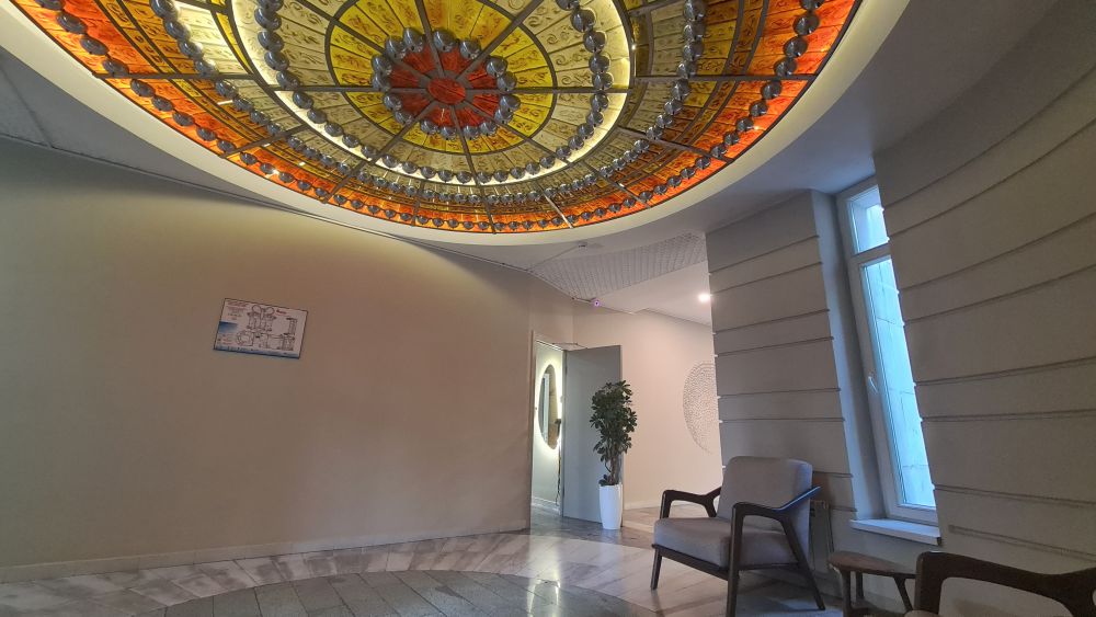A round, stained glass panel in the ceiling is lit from behind.