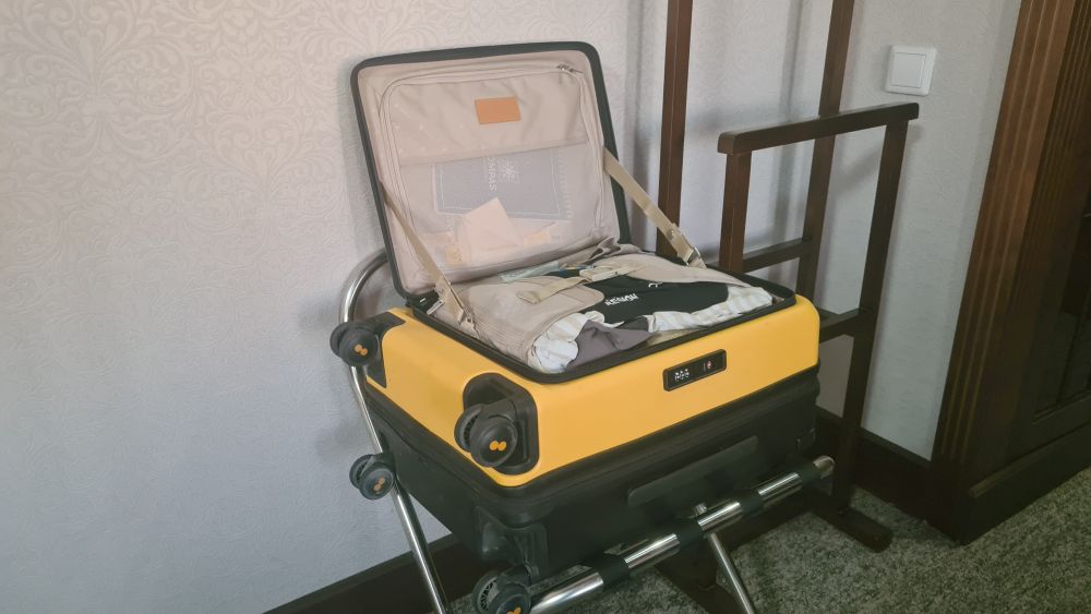A yellow-and-black bag lying on a luggage rack, lid open and standing up vertically.