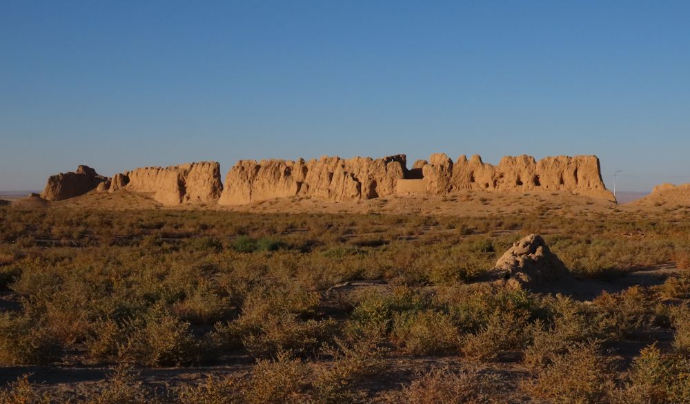There is a jagged wall of eroded stone in the distance.