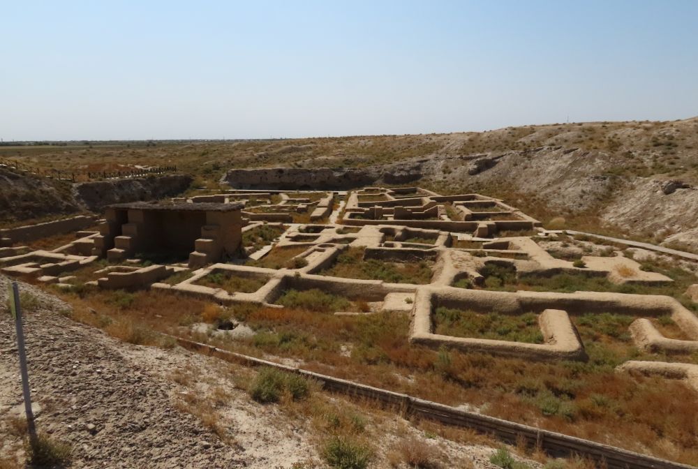 Ruins show just the outlines of buildings and their rooms, with the surrounding land several meters higher.